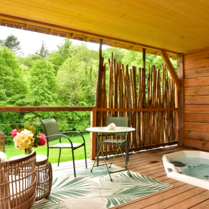 Hébergement insolite en Bretagne : terrasse en bois avec jacuzzi et vue sur la nature.