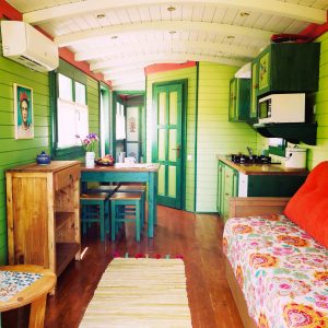 Charmante cabane colorée avec un intérieur en bois et des touches artistiques.