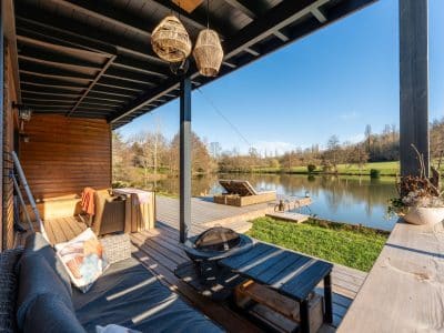 Cabane en bois au bord de leau, avec terrasse et vue sur le lac. Ambiance paisible.