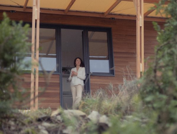 Chalet moderne avec terrasse, offrant une vue sur la nature environnante.