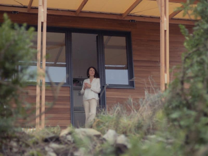 Chalet moderne avec terrasse, offrant une vue sur la nature environnante.