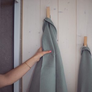 Cabane en bois avec serviettes suspendues sur un mur clair et moderne.