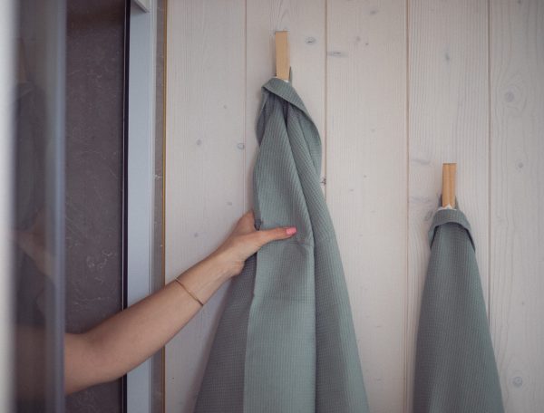 Cabane en bois avec serviettes suspendues sur un mur clair et moderne.