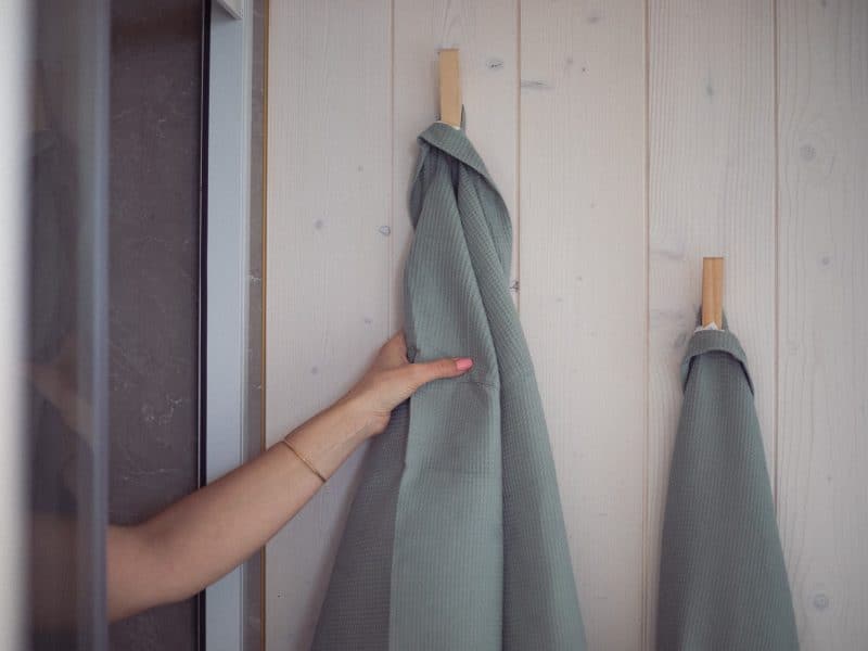 Cabane en bois avec serviettes suspendues sur un mur clair et moderne.