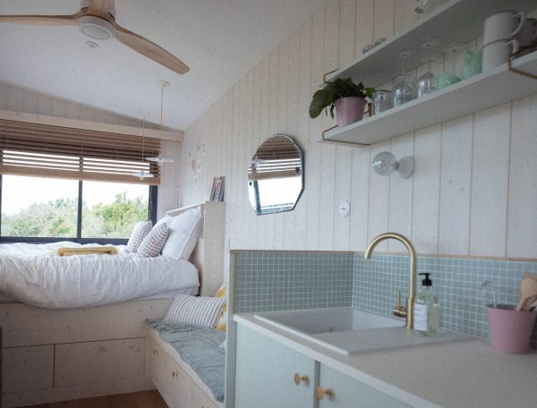 Chambre dhôtes moderne avec lit douillet et cuisine lumineuse.