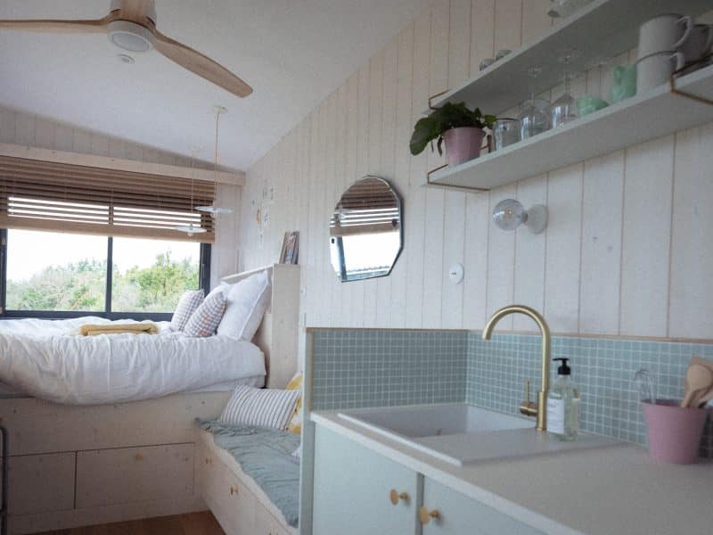 Chambre dhôtes moderne avec lit douillet et cuisine lumineuse.
