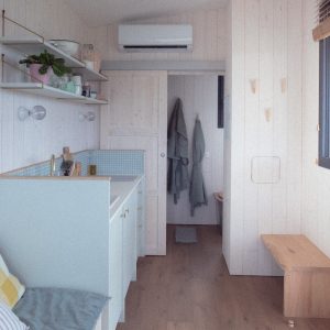 Intérieur dun chalet moderne, lumineux, avec cuisine équipée et vue sur la nature.