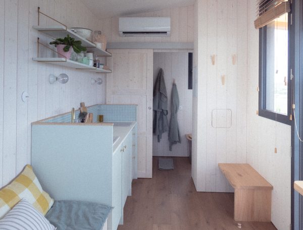 Intérieur dun chalet moderne, lumineux, avec cuisine équipée et vue sur la nature.