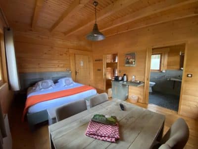 Chalet en bois chaleureux avec lit douillet et table en bois dans le Languedoc-Roussillon.