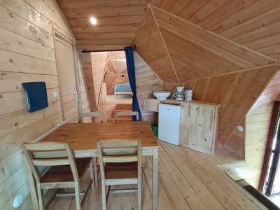 Hébergement insolite en Auvergne : chalet en bois avec cuisine et coin repas chaleureux.