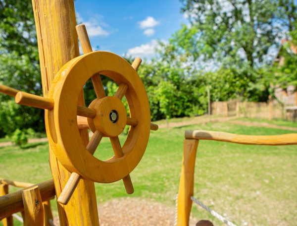 Aire de jeux en bois avec baromètre, idéale pour les familles en vacances.