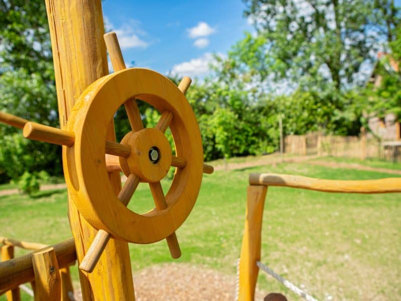 Aire de jeux en bois avec baromètre, idéale pour les familles en vacances.