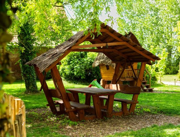 Abri en bois avec table et bancs, idéal pour un séjour en pleine nature.