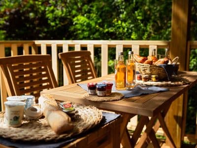 Hébergement insolite en cabane, terrasse en bois avec petit-déjeuner gourmand.