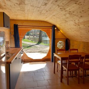 Hébergement insolite en Auvergne : cabane en bois avec vue sur le lac et cuisine équipée.