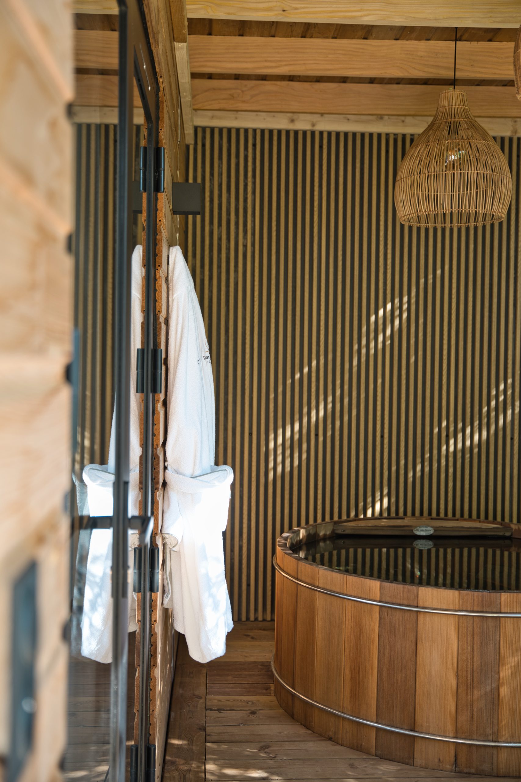 Bain nordique Hébergement insolite : chalet en bois avec un bain nordique et des détails en bambou.