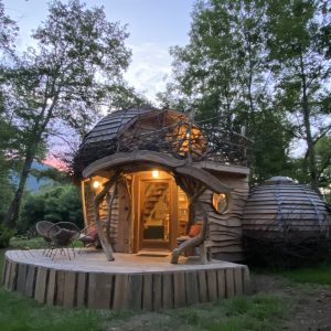 Cabane en bois originale avec une terrasse en bois et des détails naturels.