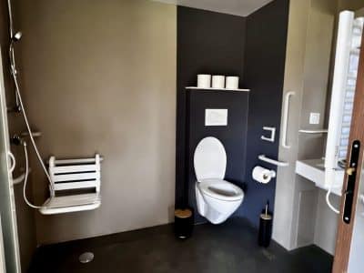 Salle de bain moderne dun hébergement insolite en Auvergne-Rhône-Alpes, avec douche accessible.
