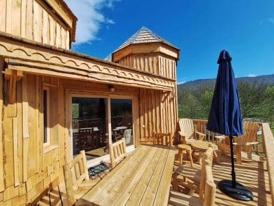 Hébergement insolite en bois avec terrasse et vue sur les montagnes en Auvergne-Rhône-Alpes.