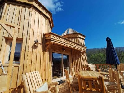Hébergement insolite en bois avec terrasse ensoleillée en Auvergne-Rhône-Alpes.