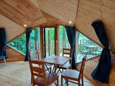 Cabane en bois à Auvergne, avec grandes fenêtres et vue sur la nature.
