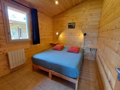Chalet en bois chaleureux avec lit double et décoration en bois naturel.