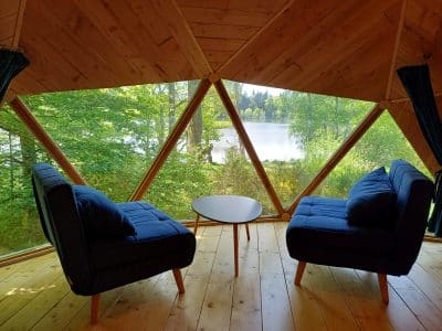 Hébergement insolite en Auvergne : cabane géodésique avec vue sur le lac et nature verdoyante.