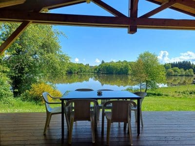 Hébergement insolite en Auvergne, avec vue sur un lac depuis la terrasse en bois.