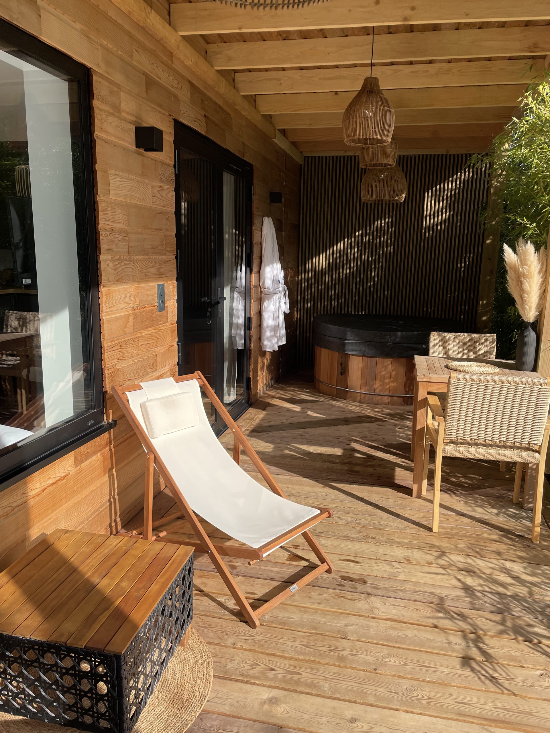 Exterieur et terrasse 2 Hébergement insolite en bois avec terrasse, bain nordique et chaises confortables.