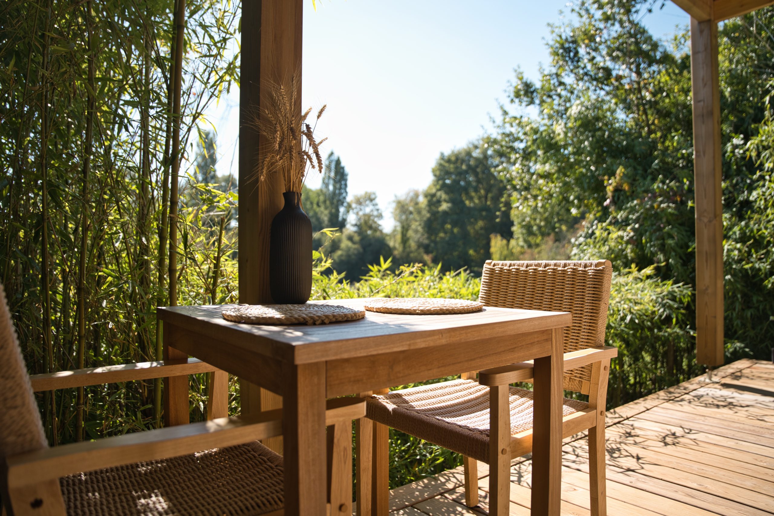 Extérieure et terrasse Hébergement insolite : cabane en bois avec terrasse ensoleillée et vue sur la nature.