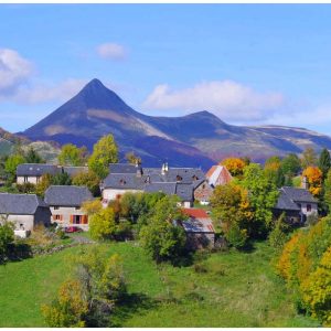 Charmant gîte en pleine nature, avec vue sur une montagne majestueuse et des arbres colorés.