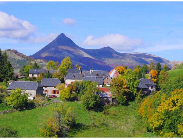 Charmant gîte en pleine nature, avec vue sur une montagne majestueuse et des arbres colorés.