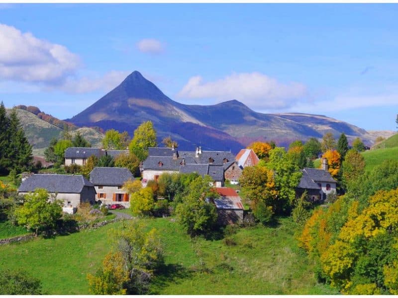 Charmant gîte en pleine nature, avec vue sur une montagne majestueuse et des arbres colorés.