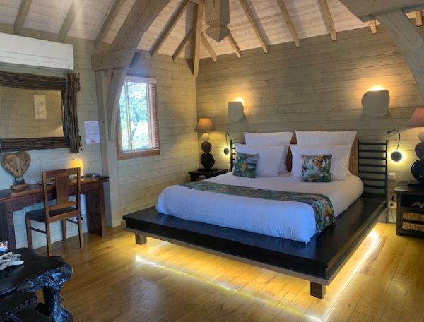 Chalet moderne avec lit king-size et éclairage doux, ambiance chaleureuse et accueillante.