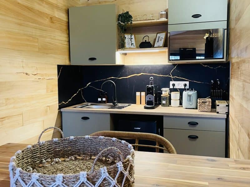 Chalet moderne avec cuisine en bois, plan de travail élégant et décoration chaleureuse.