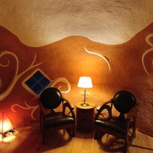Hébergement insolite en Limousin : intérieur coloré avec chaises en cuir et lumière douce.