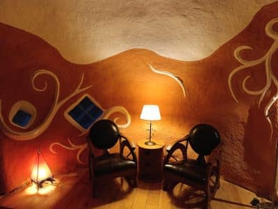 Hébergement insolite en Limousin : intérieur coloré avec chaises en cuir et lumière douce.