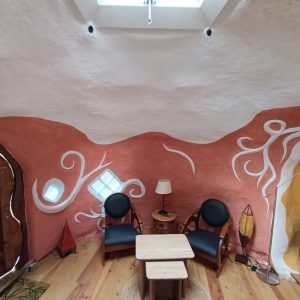 Hébergement insolite à Limousin : intérieur coloré avec murs arrondis et mobilier en bois.