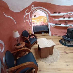 Hébergement insolite en forme de grotte à Limousin, avec murs colorés et coin salon.