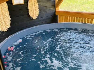 Hébergement insolite en Midi-Pyrénées avec un jacuzzi décoré de pétales de fleurs.