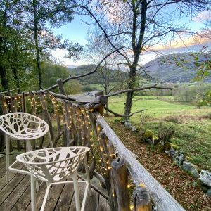 Cabane perchée en Midi-Pyrénées avec vue sur la vallée et chaises modernes.