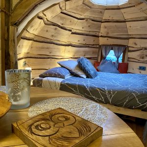 Hébergement insolite en Midi-Pyrénées : cabane en bois avec lit douillet et décor naturel.