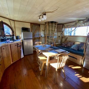 Cabane en bois dans les Midi-Pyrénées, avec cuisine équipée et coin salon lumineux.