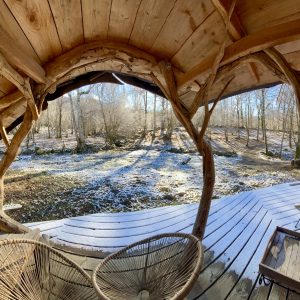 Hébergement insolite en cabane, vue sur la nature enneigée et terrasse en bois.