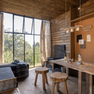 Hébergement insolite en bois à Champagne-Ardennes, avec grandes fenêtres et mobilier naturel.