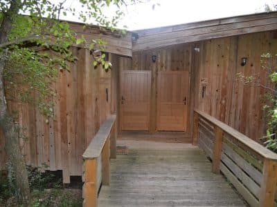 Cabane en bois au cœur de la nature, avec une terrasse en bois accueillante.