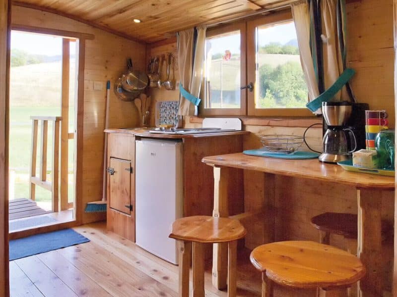 Cabane en bois cosy avec cuisine équipée et vue sur la nature en Auvergne-Rhône-Alpes.