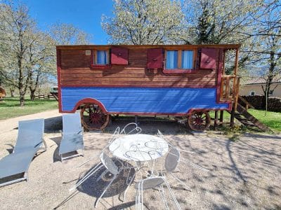 Charmante roulotte colorée avec terrasse et mobilier extérieur en Auvergne-Rhône-Alpes.