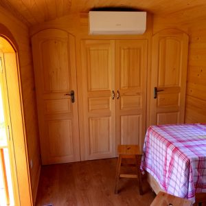 Intérieur dun chalet en bois, avec une table à carreaux et des portes en bois.