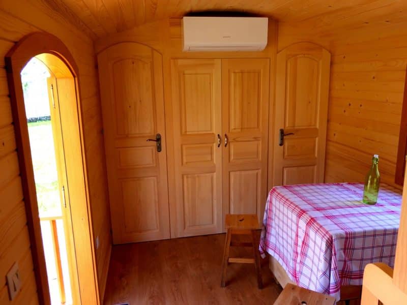 Intérieur dun chalet en bois, avec une table à carreaux et des portes en bois.